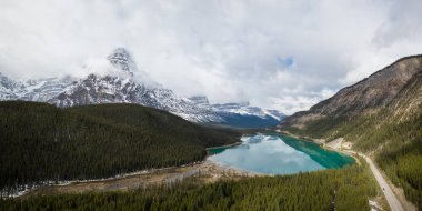 Hava panoramik manzaralı bir bulutlu gün boyunca Kanada Rocky Dağları ile çevrili bir buzul Gölü. Banff, Alberta, Kanada içinde alınan.