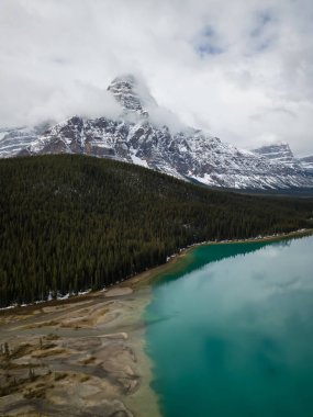 Hava panoramik manzaralı bir bulutlu gün boyunca Kanada Rocky Dağları ile çevrili bir buzul Gölü. Banff, Alberta, Kanada içinde alınan.