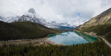 Hava panoramik manzaralı bir bulutlu gün boyunca Kanada Rocky Dağları ile çevrili bir buzul Gölü. Banff, Alberta, Kanada içinde alınan.