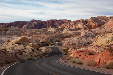 Doğal görünümü bir bulutlu ve güneşli gün boyunca çölde yolda. Valley of Fire State Park, Nevada, Amerika Birleşik Devletleri'nde çekilen.