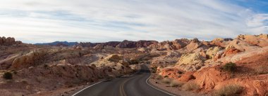 Doğa manzaralı panoramik bir bulutlu ve güneşli gün boyunca çölde yolda. Valley of Fire State Park, Nevada, Amerika Birleşik Devletleri'nde çekilen.