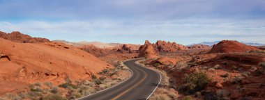 Doğa manzaralı panoramik bir bulutlu ve güneşli gün boyunca çölde yolda. Valley of Fire State Park, Nevada, Amerika Birleşik Devletleri'nde çekilen.