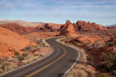 Doğal görünümü bir bulutlu ve güneşli gün boyunca çölde yolda. Valley of Fire State Park, Nevada, Amerika Birleşik Devletleri'nde çekilen.