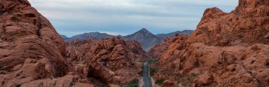 Aerial panoramic view on the scenic road in the desert during a cloudy sunrise. Taken in Valley of Fire State Park, Nevada, United States. clipart
