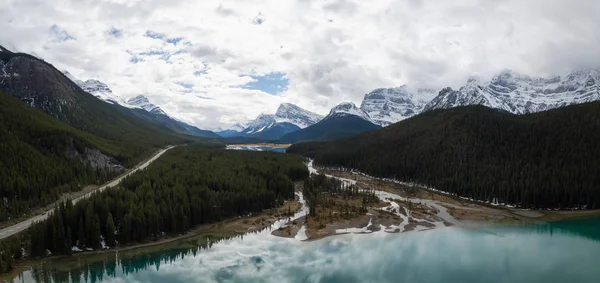 Hava panoramik manzaralı bir bulutlu gün boyunca Kanada Rocky Dağları ile çevrili bir buzul Gölü. Banff, Alberta, Kanada içinde alınan.