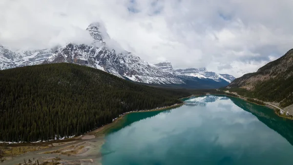 Hava panoramik manzaralı bir bulutlu gün boyunca Kanada Rocky Dağları ile çevrili bir buzul Gölü. Banff, Alberta, Kanada içinde alınan.