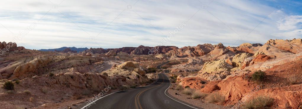 Scenic panoramic view on the road in the desert during a cloudy and sunny day. Taken in Valley of Fire State Park, Nevada, United States.