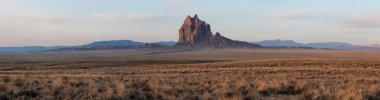 Bir kuru çöl dağ tepe canlı bulutlu gün doğumu sırasında arka planda ile dramatik panoramik manzara görünümü. Shiprock, New Mexico, Amerika Birleşik Devletleri, alınan.
