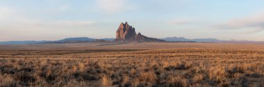 Bir kuru çöl dağ tepe canlı bulutlu gün doğumu sırasında arka planda ile dramatik panoramik manzara görünümü. Shiprock, New Mexico, Amerika Birleşik Devletleri, alınan.