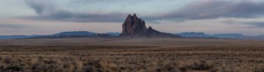 Bir kuru çöl dağ tepe canlı bulutlu gün doğumu sırasında arka planda ile dramatik panoramik manzara görünümü. Shiprock, New Mexico, Amerika Birleşik Devletleri, alınan.