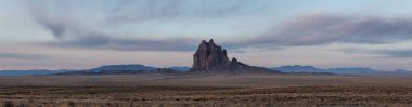 Bir kuru çöl dağ tepe canlı bulutlu gün doğumu sırasında arka planda ile dramatik panoramik manzara görünümü. Shiprock, New Mexico, Amerika Birleşik Devletleri, alınan.