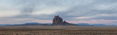 Bir kuru çöl dağ tepe canlı bulutlu gün doğumu sırasında arka planda ile dramatik panoramik manzara görünümü. Shiprock, New Mexico, Amerika Birleşik Devletleri, alınan.