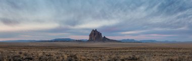 Bir kuru çöl dağ tepe canlı bulutlu gün doğumu sırasında arka planda ile dramatik panoramik manzara görünümü. Shiprock, New Mexico, Amerika Birleşik Devletleri, alınan.