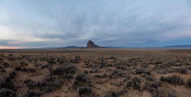 Bir kuru çöl dağ tepe canlı bulutlu gün doğumu sırasında arka planda ile dramatik panoramik manzara görünümü. Shiprock, New Mexico, Amerika Birleşik Devletleri, alınan.