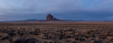 Bir kuru çöl dağ tepe canlı bulutlu gün doğumu sırasında arka planda ile dramatik panoramik manzara görünümü. Shiprock, New Mexico, Amerika Birleşik Devletleri, alınan.