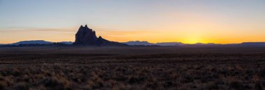 Panoramik manzaralı bir kuru çöl dağ tepe ile canlı bir gün batımı sırasında arka planda dikkat çekici. Shiprock, New Mexico, Amerika Birleşik Devletleri, alınan.