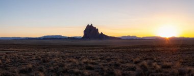 Panoramik manzaralı bir kuru çöl dağ tepe ile canlı bir gün batımı sırasında arka planda dikkat çekici. Shiprock, New Mexico, Amerika Birleşik Devletleri, alınan.