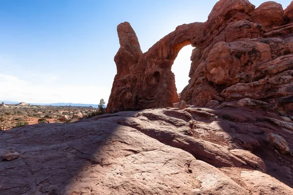 Scenic path leading to an Arch rock formation during a vibrant sunny day. Taken in Arches National Park, located near Moab, Utah, United States.