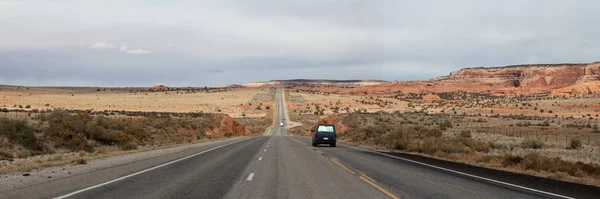 Panoramic view of a highway in the desert during a vibrant sunny day. Located near Monticello, Utah, United States.