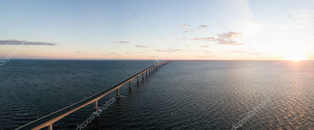 Aerial Panoramic view of Confederation Bridge to Prince Edward Island during a vibrant sunny sunrise. Taken in Cape Jourimain National Wildlife Area, New Brunswick, Canada.