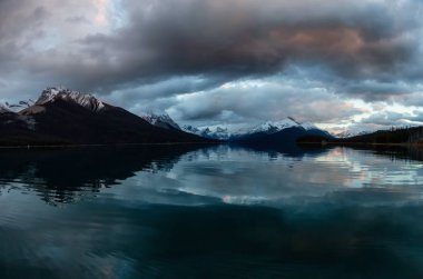 Panoramik manzaralı dramatik bir bulutlu gün batımı sırasında bir buzul Gölü. Maligne gölde, Jasper National Park, Alberta, Kanada alınan.