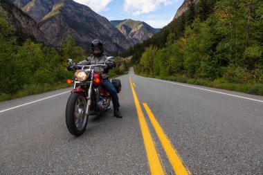 Canlı bir güneşli gün boyunca güzel Kanada manzara keyfi bir motosiklet üzerinde Advanturous adam. Duffey göl kenarında Pemberton, British Columbia, Kanada çekilmiş.