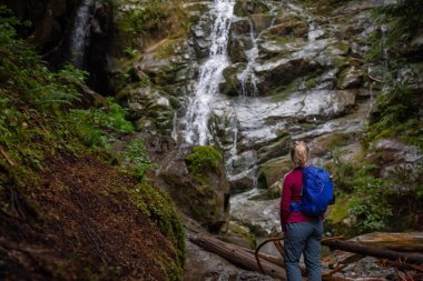 Maceracı kadın uzun yürüyüşe çıkan kimse bir şelale güzel bir manzarasına sisli bir gün zarfında keyif alıyor. MT benden, North Vancouver, British Columbia, Kanada alınan.