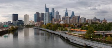 Philadelphia, Pennsylvania, United States - October 28, 2018: Panoramic view of a modern Downtown City during a cloudy day. clipart