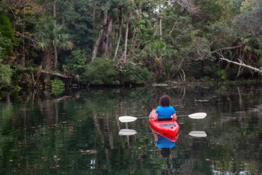 Maceracı kız bir nehir kanosu ağaçlarıyla kaplı. Orlando, Florida, Amerika Birleşik Devletleri batısında bulunan Chassahowitzka Nehri'nde alınan.