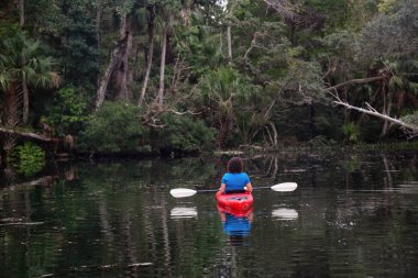 Maceracı kız bir nehir kanosu ağaçlarıyla kaplı. Orlando, Florida, Amerika Birleşik Devletleri batısında bulunan Chassahowitzka Nehri'nde alınan.
