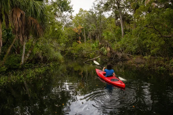 Maceracı kız bir nehir kanosu ağaçlarıyla kaplı. Orlando, Florida, Amerika Birleşik Devletleri batısında bulunan Chassahowitzka Nehri'nde alınan.