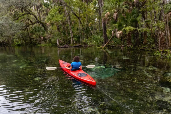 Maceracı kız bir nehir kanosu ağaçlarıyla kaplı. Orlando, Florida, Amerika Birleşik Devletleri batısında bulunan Chassahowitzka Nehri'nde alınan.