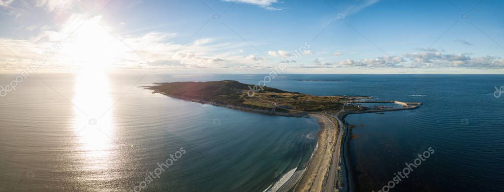 Aerial panoramic view of a scenic road during a vibrant sunny sunset.Taken in Cow Head, Newfoundland, Canada.