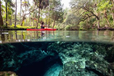 Bir sualtı mağara oluşumu yakınında bir gölde kano bir kız resmi üzerinde ve altında. Alınan 7 Sisters Springs, Chassahowitzka Nehri, Florida, Amerika Birleşik Devletleri.