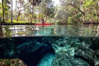 Bir sualtı mağara oluşumu yakınında bir gölde kano bir kız resmi üzerinde ve altında. Alınan 7 Sisters Springs, Chassahowitzka Nehri, Florida, Amerika Birleşik Devletleri.