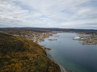 Havadan görünümü bir bulutlu gün boyunca kayalık bir Atlantik Okyanusu kıyısında küçük bir kasaba. St. Anthony, Newfoundland, Kanada'da alınan.
