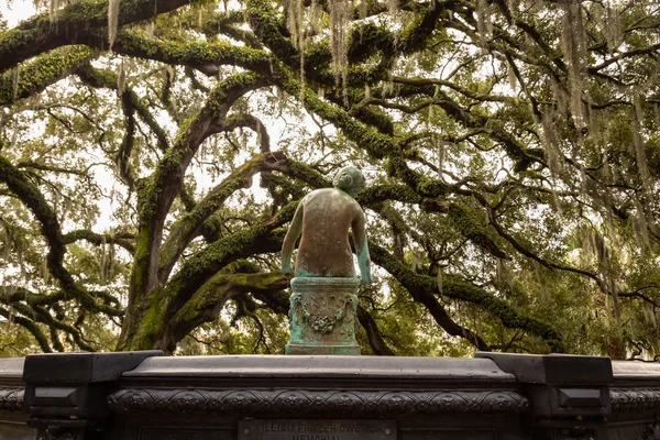 Old rusty statue in a park surrounded by beautiful trees during a foggy morning. Taken in City Park, New Orleans, Louisiana, United States.