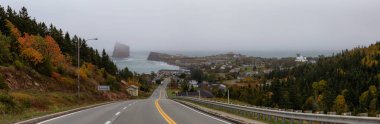 Panoramik bir yol sisli bir gün zarfında Atlantik Okyanusu kıyısında güzel bir modern şehre lider. Perce, Quebec, Kanada'da alınan.
