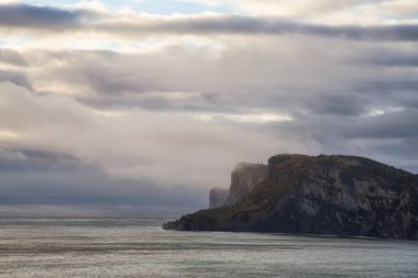 Kayalık bir kıyı şeridi manzara bulutlu gün doğumu sırasında dikkat çekici. Forillon Milli Parkı'nda, Gaspe, Quebec, Kanada yakınlarında alınan.
