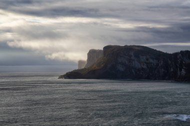 Kayalık bir kıyı şeridi manzara bulutlu gün doğumu sırasında dikkat çekici. Forillon Milli Parkı'nda, Gaspe, Quebec, Kanada yakınlarında alınan.
