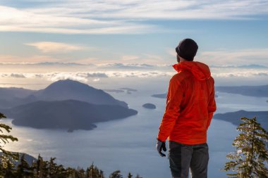 Maceracı adam kış günbatımı sırasında bir dağın tepesinde güzel manzarayı. Mnt Harvey, Vancouver, Bc, Kanada yakın üzerinde gerçekleştirilen.