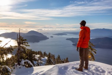 Maceracı adam kış günbatımı sırasında bir dağın tepesinde güzel manzarayı. Mnt Harvey, Vancouver, Bc, Kanada yakın üzerinde gerçekleştirilen.