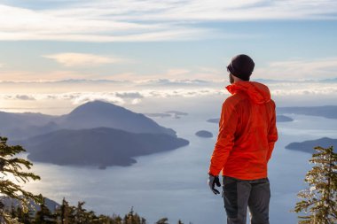 Maceracı adam kış günbatımı sırasında bir dağın tepesinde güzel manzarayı. Mnt Harvey, Vancouver, Bc, Kanada yakın üzerinde gerçekleştirilen.