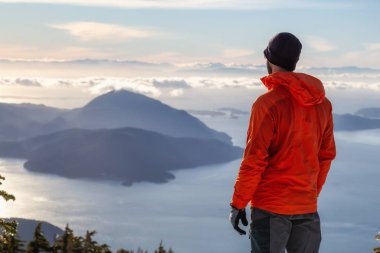 Maceracı adam kış günbatımı sırasında bir dağın tepesinde güzel manzarayı. Mnt Harvey, Vancouver, Bc, Kanada yakın üzerinde gerçekleştirilen.