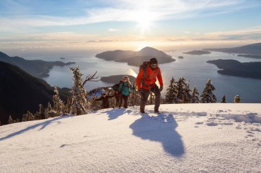Mnt Harvey, Kuzey Vancouver, Bc, Kanada - 20 Ocak 2019: maceracı arkadaş canlı kış günbatımı sırasında bir dağın tepesine hiking.
