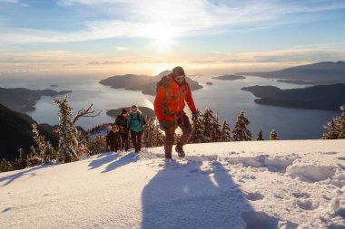 Mnt Harvey, Kuzey Vancouver, Bc, Kanada - 20 Ocak 2019: maceracı arkadaş canlı kış günbatımı sırasında bir dağın tepesine hiking.
