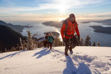 Mnt Harvey, Kuzey Vancouver, Bc, Kanada - 20 Ocak 2019: maceracı arkadaş canlı kış günbatımı sırasında bir dağın tepesine hiking.