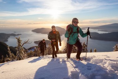 Mnt Harvey, Kuzey Vancouver, Bc, Kanada - 20 Ocak 2019: maceracı arkadaş canlı kış günbatımı sırasında bir dağın tepesine hiking.