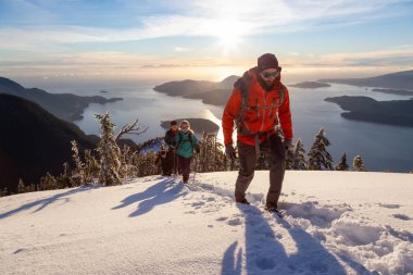 Mnt Harvey, Kuzey Vancouver, Bc, Kanada - 20 Ocak 2019: maceracı arkadaş canlı kış günbatımı sırasında bir dağın tepesine hiking.
