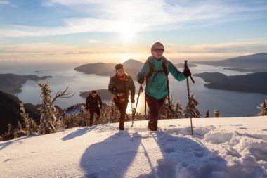 Mnt Harvey, Kuzey Vancouver, Bc, Kanada - 20 Ocak 2019: maceracı arkadaş canlı kış günbatımı sırasında bir dağın tepesine hiking.